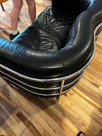 a black leather couch on a wooden floor